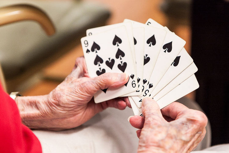 A resident holding a hand of playing cards